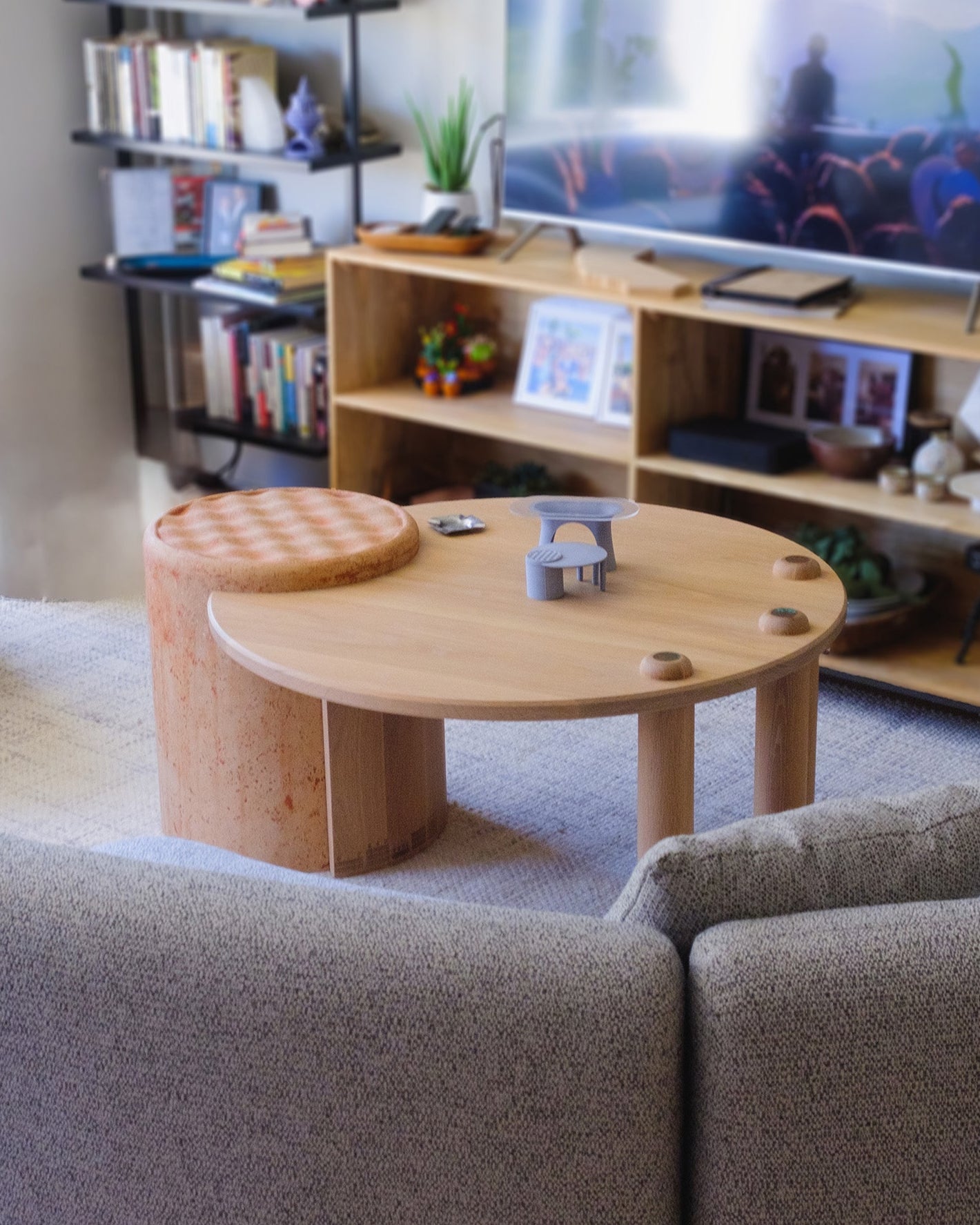 custom coffee table designed and made of white oak with a fitted concrete pillar, set in a cozy apartment living room